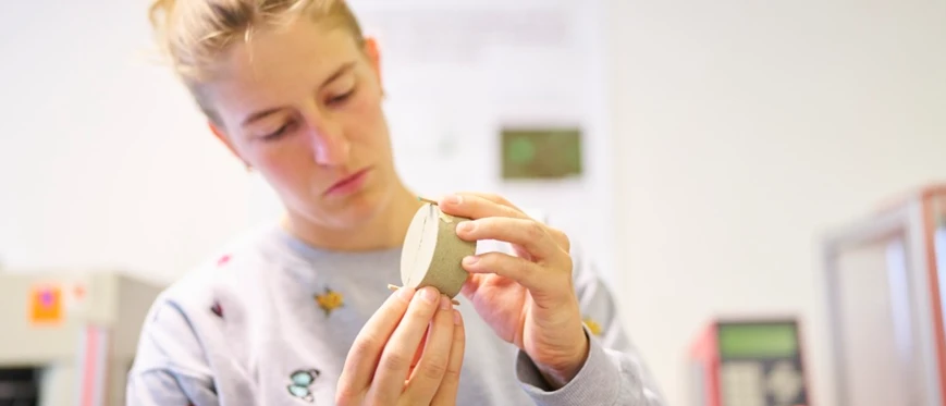 Researcher looks at something in their hands in a laboratory.