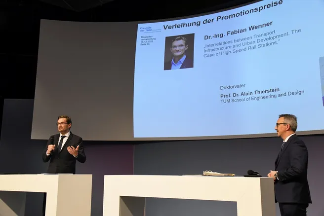 Two people on a stage during a presentation.