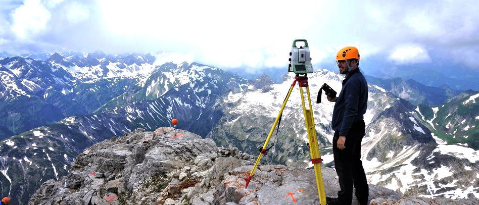 Student standing on a mountain with a measuring device